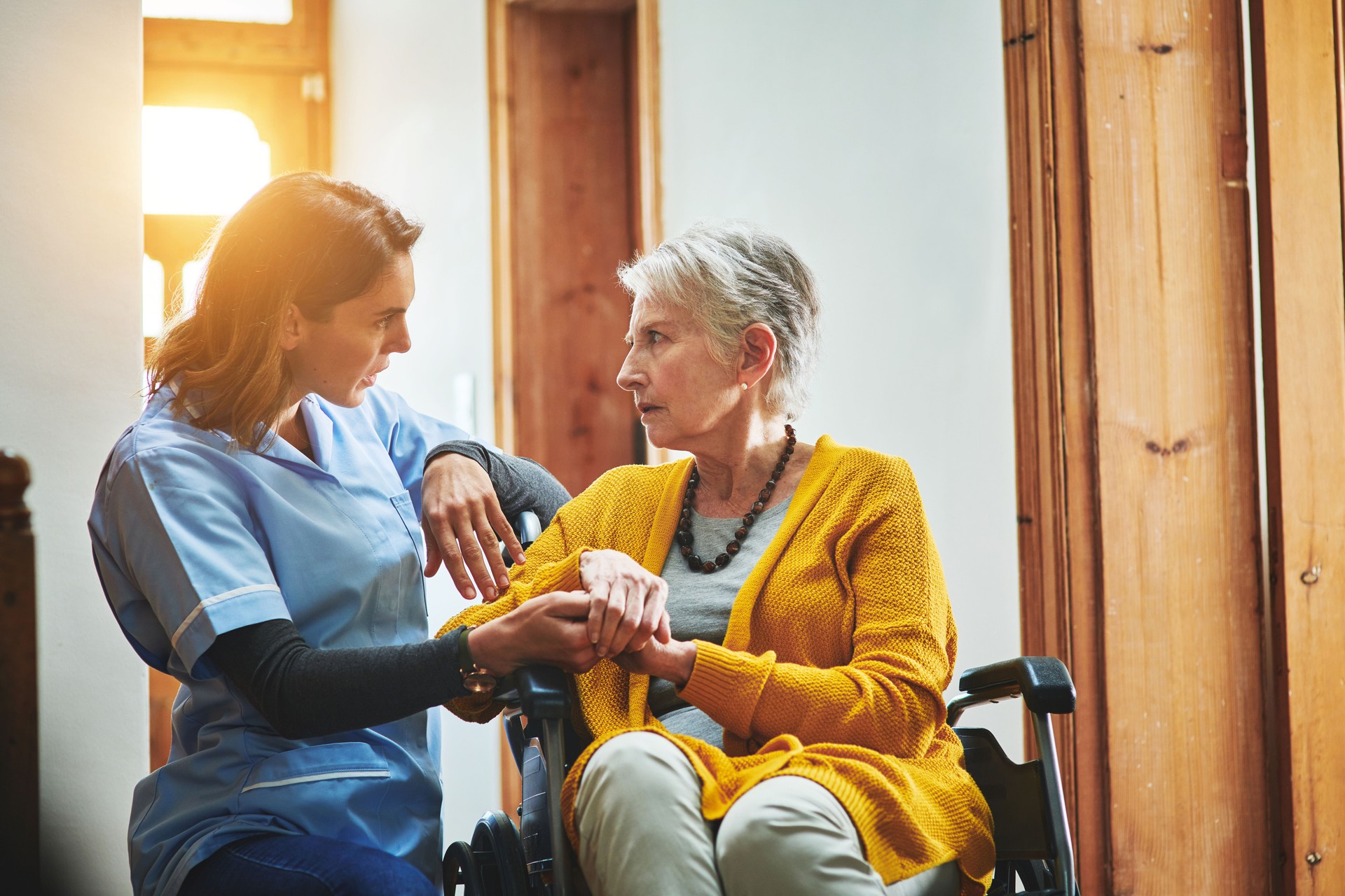 Shot of a young caregiver caring for a senior woman in a wheelchair in assisted living in Gastonia, NC.
